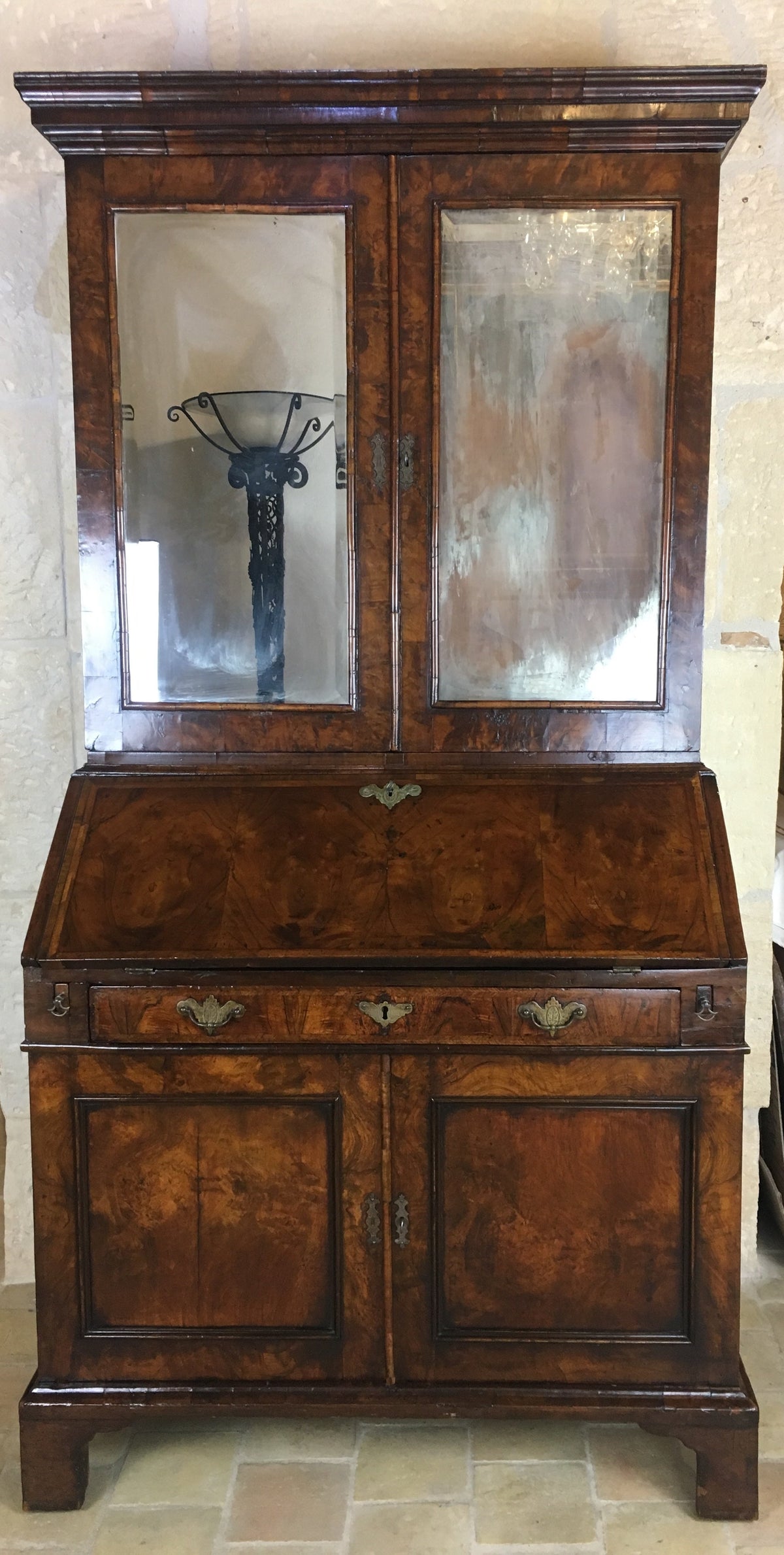 English Queen Anne period walnut secretary bookcase with double dome top and mirrored cabinet doors, early 18th century