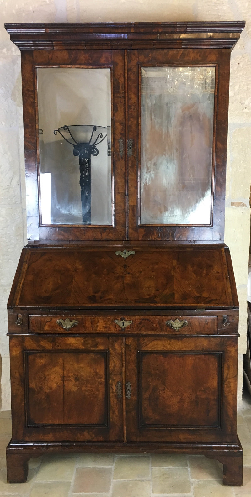 English Queen Anne period walnut secretary bookcase with double dome top and mirrored cabinet doors, early 18th century